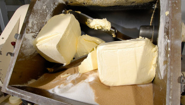 Productie van boter in een zuivelfabriek, verse boter gevormd tijdens industriële verwerking van room