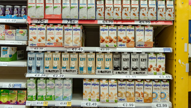 Pakken plantaardige melk uitgestald in het schap van de supermarkt.