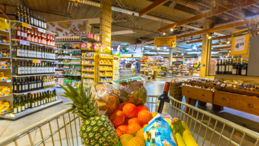 Winkelwagen met verse boodschappen in een supermarkt vol huishoud- en verzorgingsproducten
