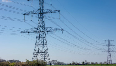 Hoogspanningslijnen en elektriciteitsmasten in een winters landschap.