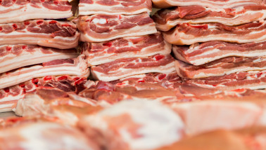 Stukken vers varkensvlees in de vitrine van de slagerijafdeling in de winkel