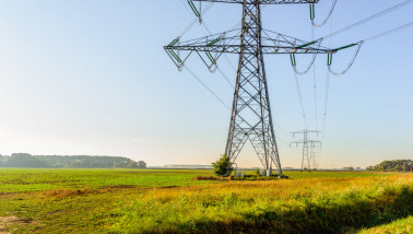 Hoogspanningslijnen en elektriciteitsmasten in een winters landschap.