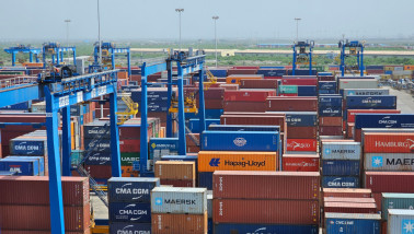 Gestapelde zeecontainers in een haven- of logistiek gebied.