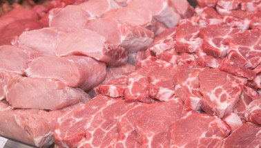 Verse stukken varkensvlees uitgestald op de toonbank van een slager