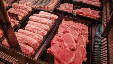 Verse stukken varkensvlees uitgestald op de toonbank van een slager