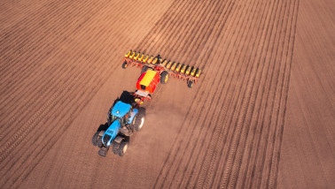 Dronebeeld van een trekker met zaaimachine op een veld tijdens het voorjaar, akkerbouwteelt