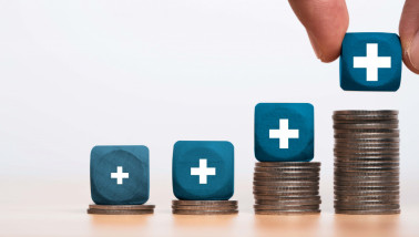 Een stapel munten en dobbelstenen met plussen daarop