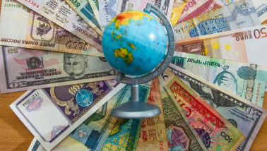 Wereldbol met biljetten van veel verschillende valuta