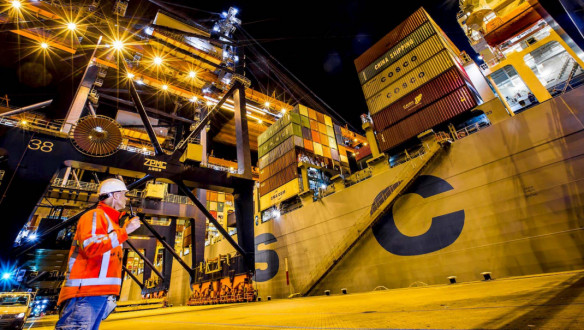Werknemer met een walkietalkie bij een containerschip, Havenbedrijf Rotterdam